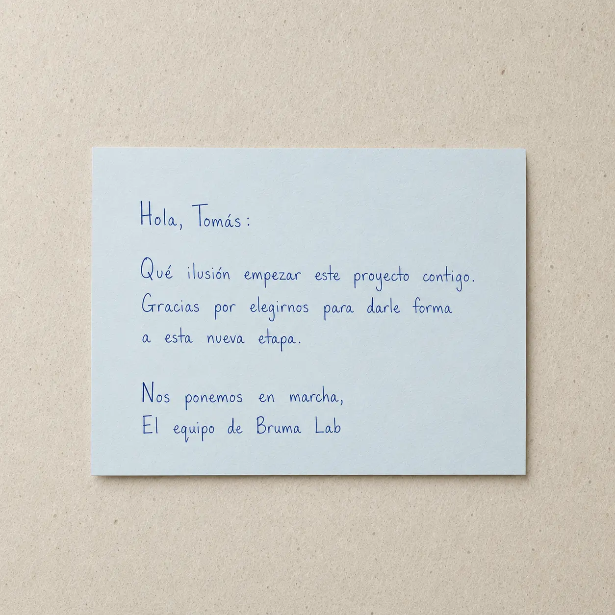 Tarjeta azul claro con nota de bienvenida a un cliente nuevo escrita en tinta azul.